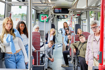 Resenärer som ger arga blickar mot en person längst bak i bussen