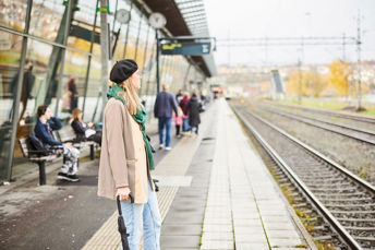 Resenär som står och väntar på tåget vid tågrälsen