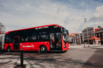 Bild på en röd stadsbuss i Jönköping centrum, hållplats Rådhusparken. 