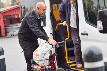 Bild på servicereseresenär som får hjälp ut ur ett fordon av föraren.